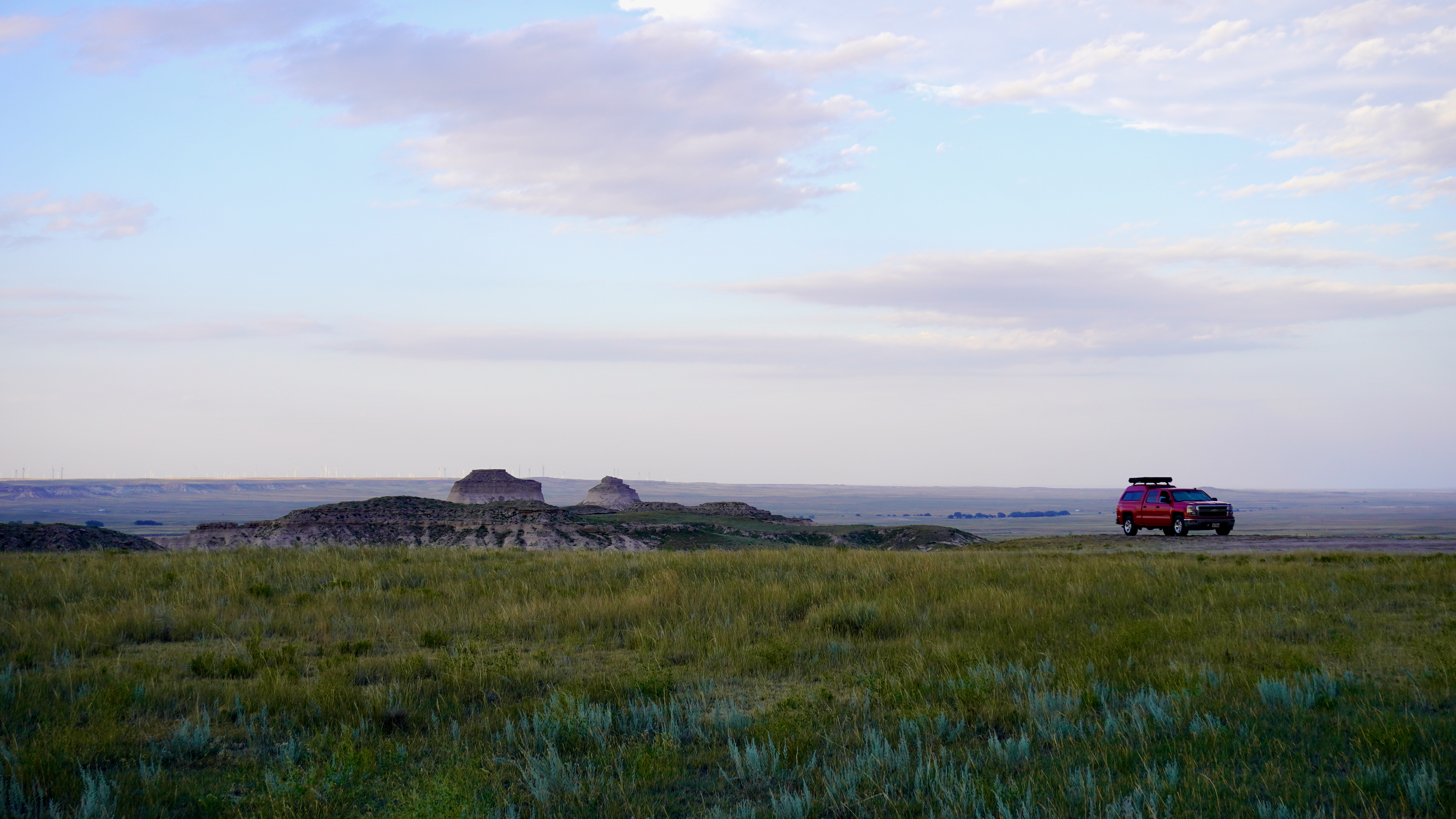 a red truck and pawnee buttes in the background