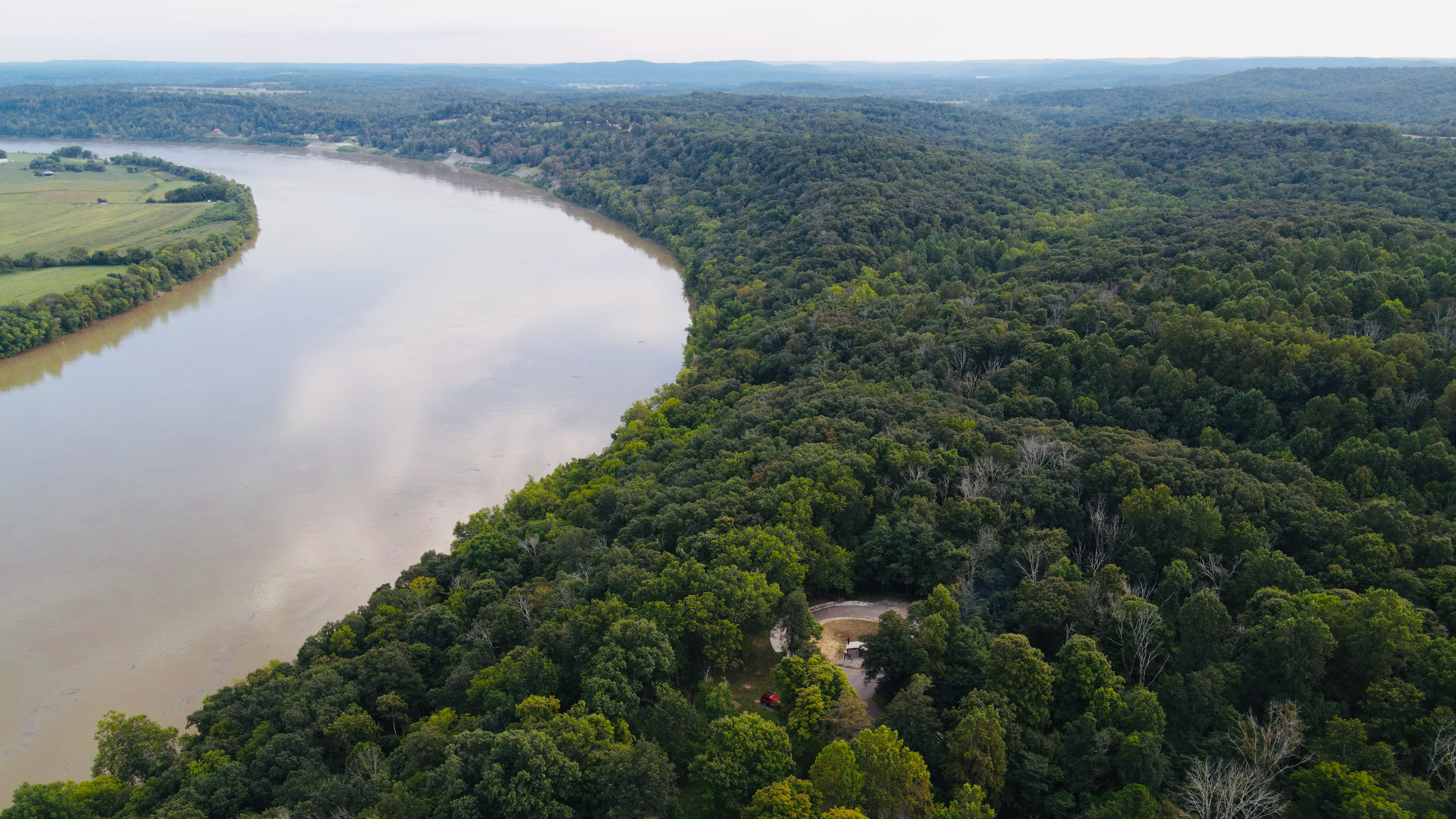 a drone picture of the campsite and the surrounding forest with the ohio river flowing by