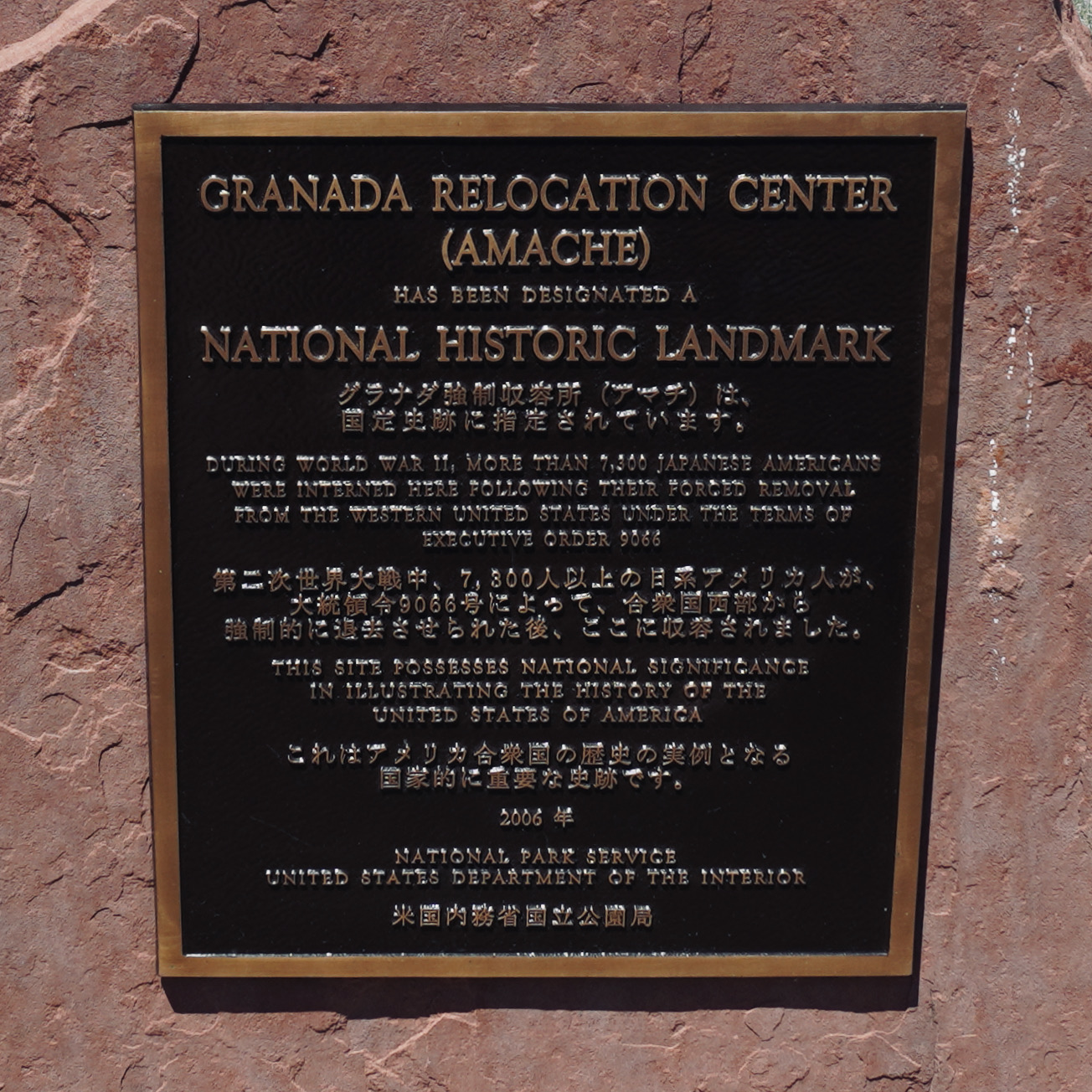 a bronze and stone historical landmark sign for grenada relocation center also called amache