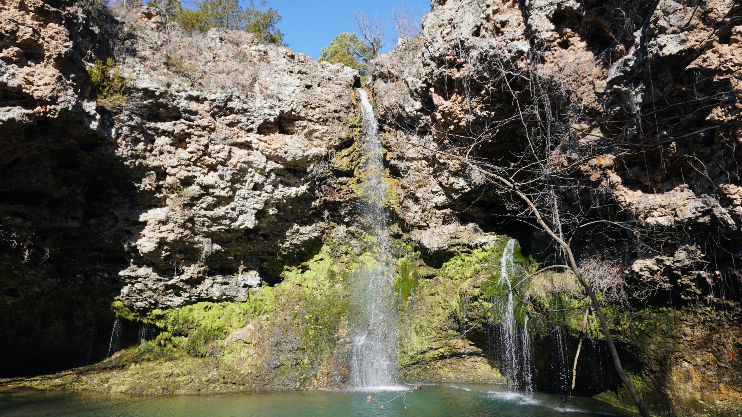 green grass and brown rock around dripping springs waterfall Oklahoma