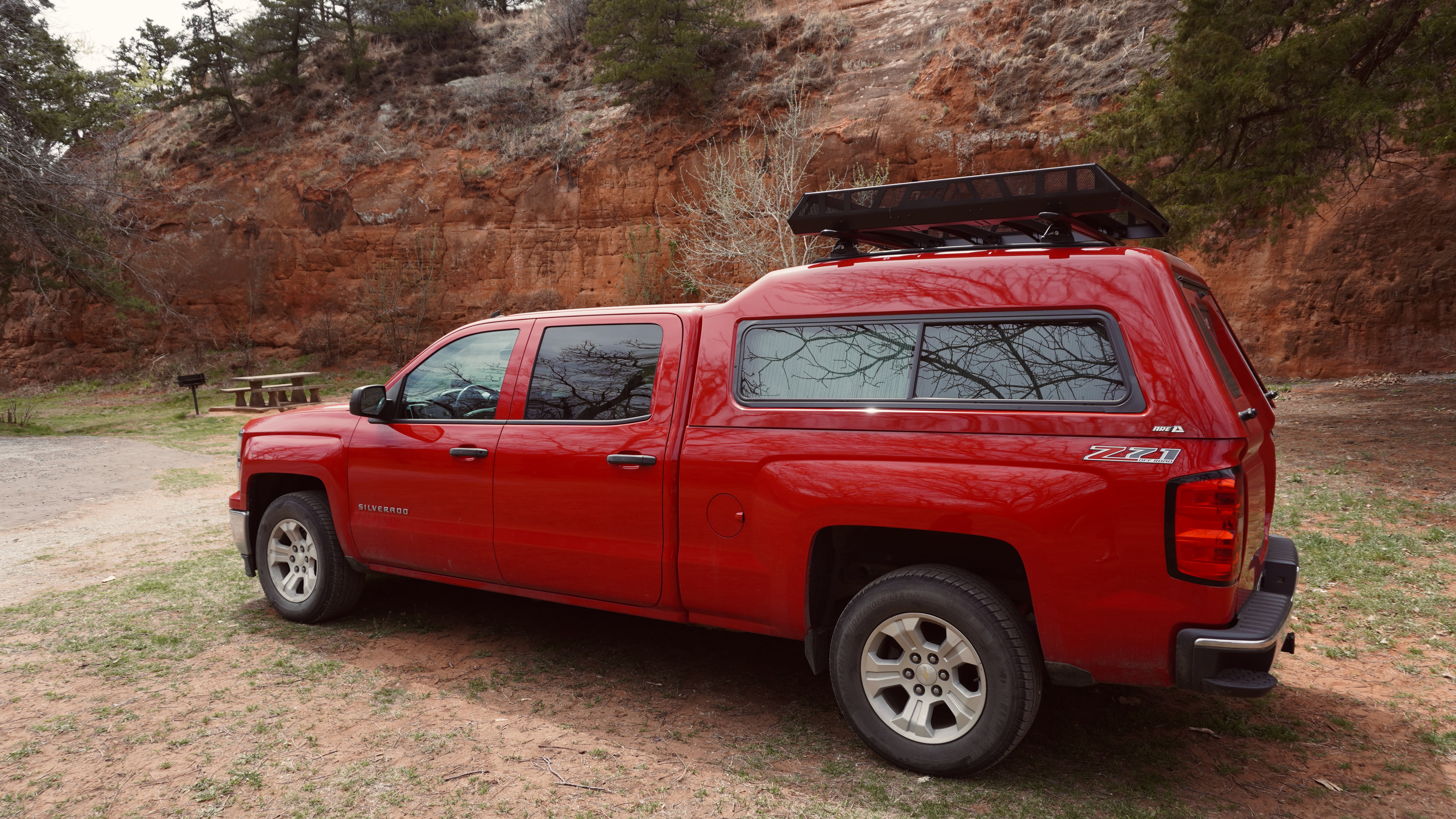 a red chevy truck with red sandstone cliffs behind